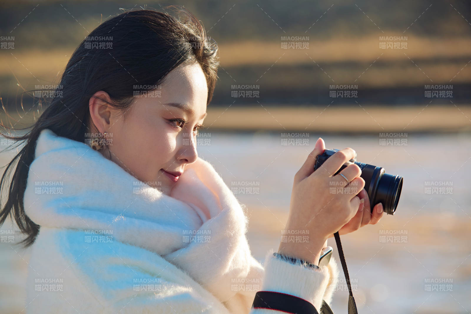 拿着相机的美女摄影师在深秋的户外拍摄图片