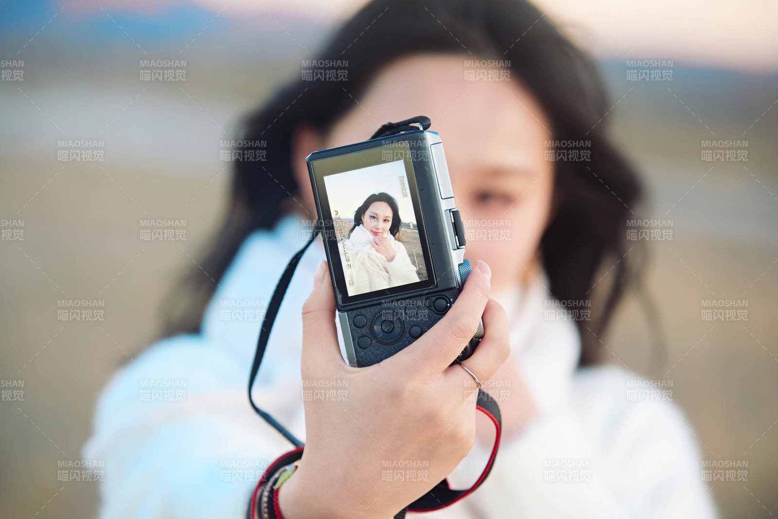 秋天夕阳下手持相机自拍的亚洲美女图片