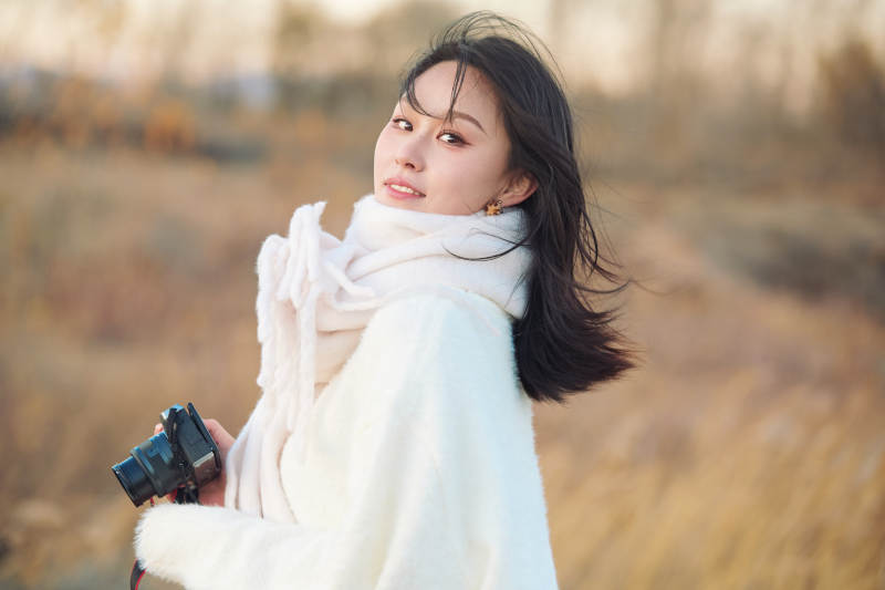 秋天夕阳下手持相机自拍的亚洲美女图片