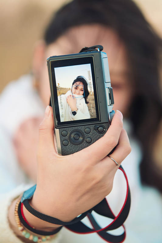 秋天夕阳下手持相机自拍的亚洲美女图片
