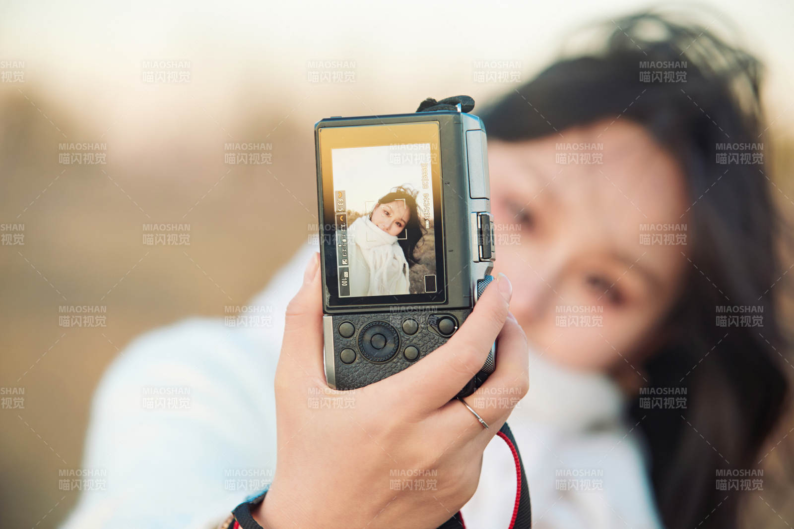 秋天夕阳下手持相机自拍的亚洲美女图片