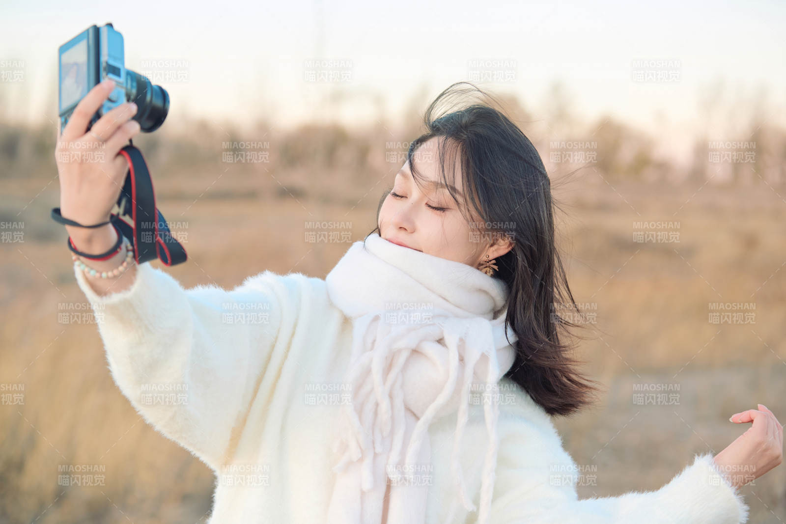 秋天夕阳下手持相机自拍的亚洲美女图片