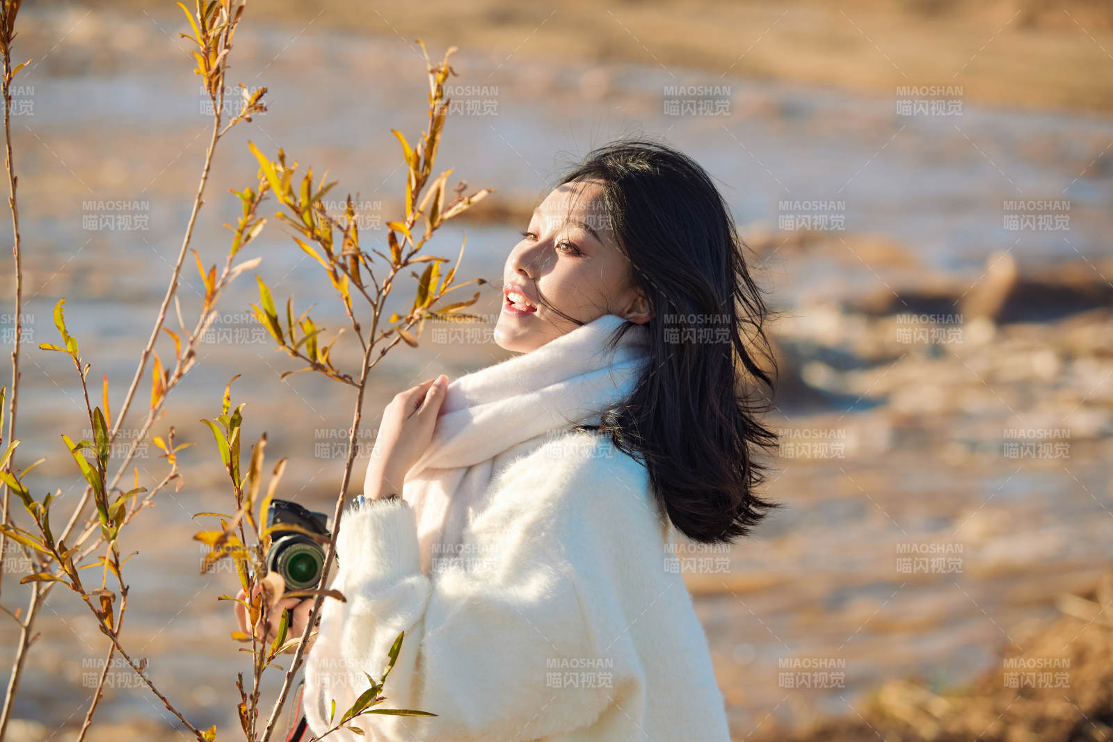 拿着相机的美女摄影师在深秋的户外拍摄图片