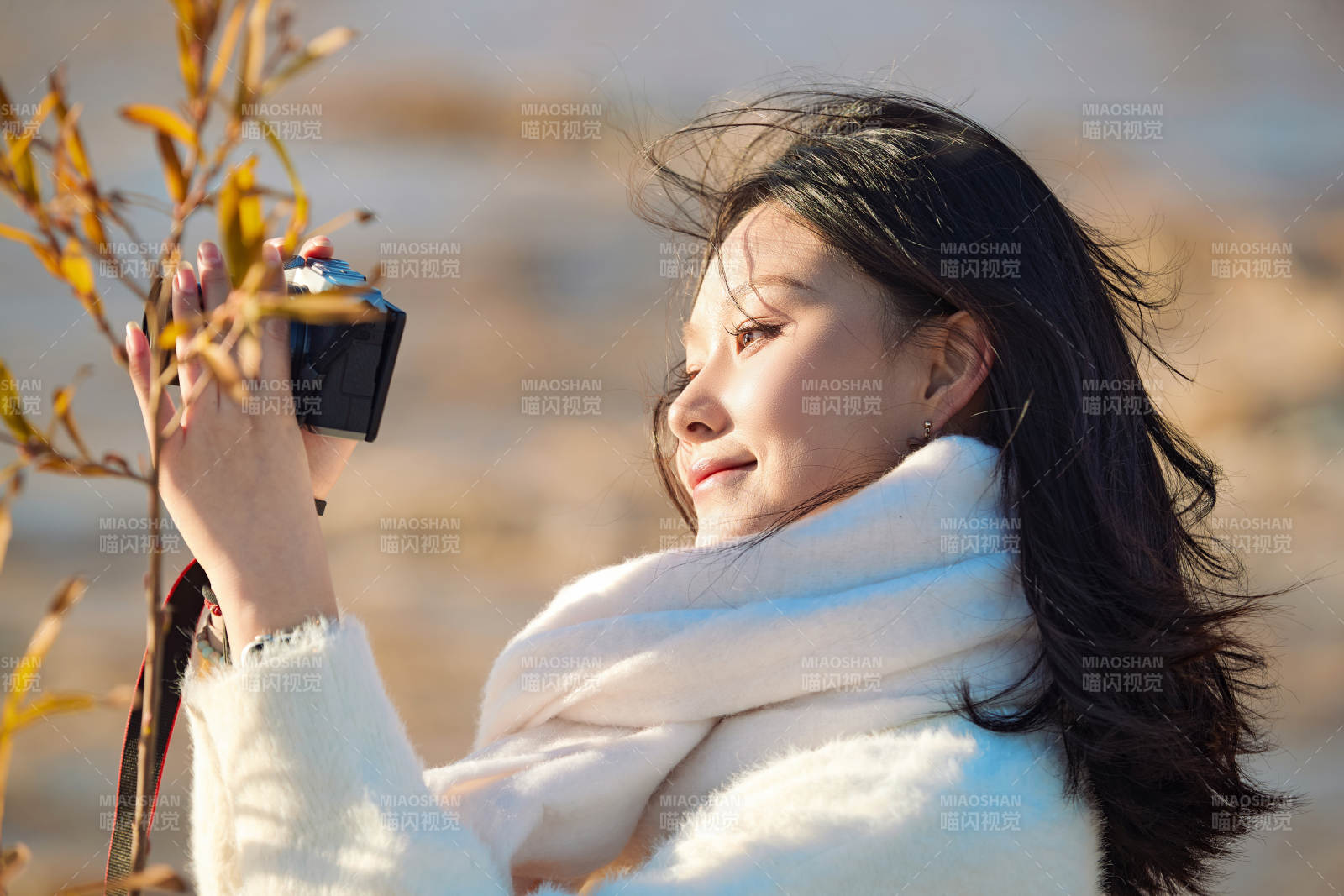 拿着相机的美女摄影师在深秋的户外拍摄图片