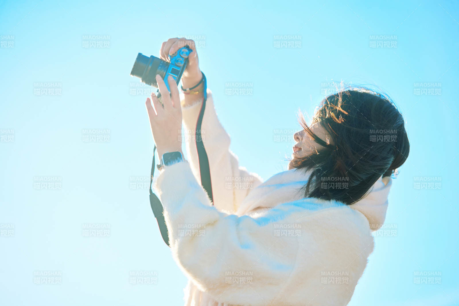 拿着相机的美女摄影师在深秋的户外拍摄图片