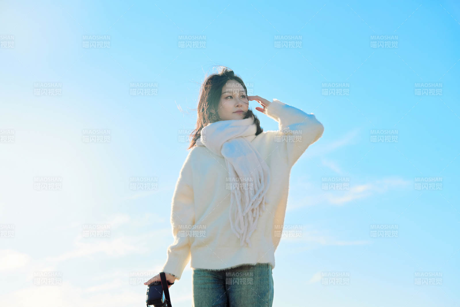 拿着相机的美女摄影师在深秋的户外拍摄图片