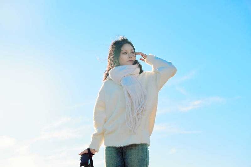 拿着相机的美女摄影师在深秋的户外拍摄图片