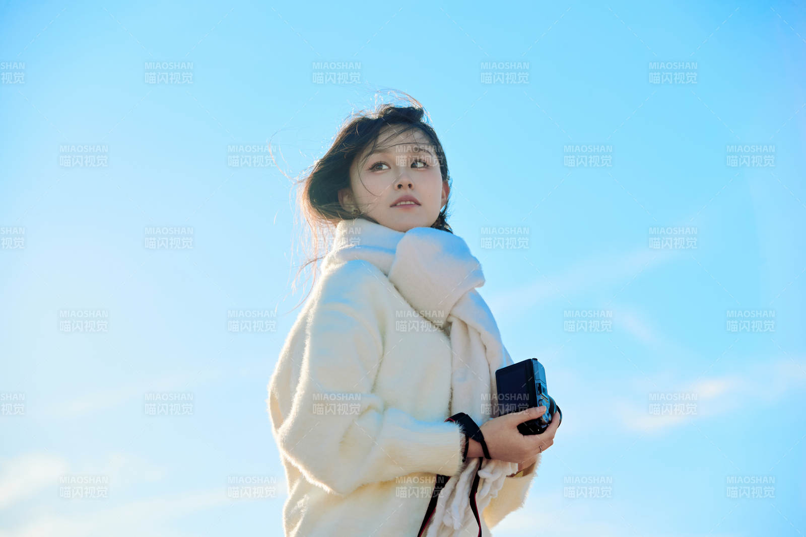 拿着相机的美女摄影师在深秋的户外拍摄图片