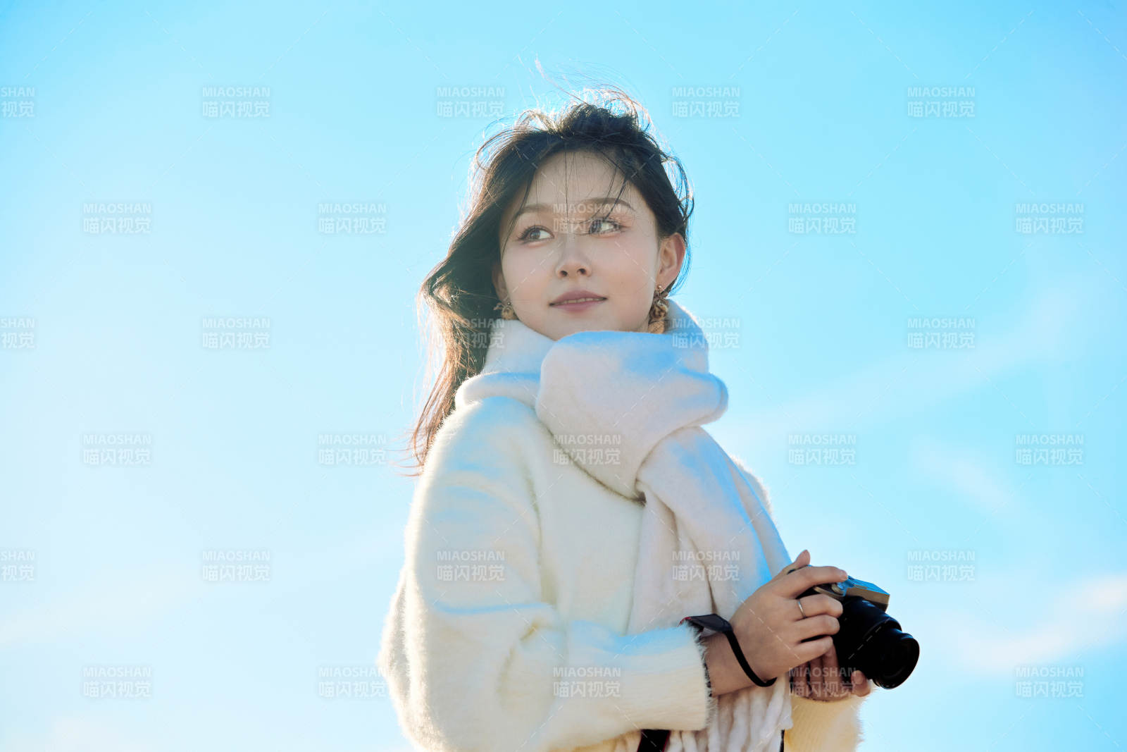 拿着相机的美女摄影师在深秋的户外拍摄图片