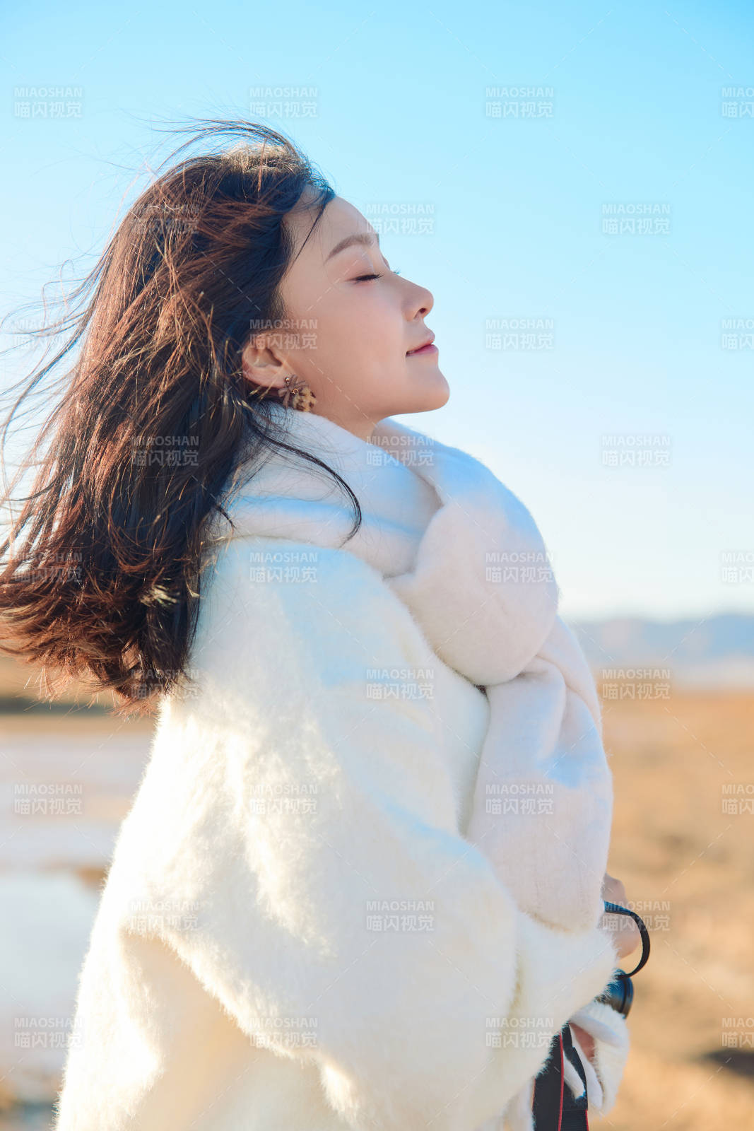 拿着相机的美女摄影师在深秋的户外拍摄图片