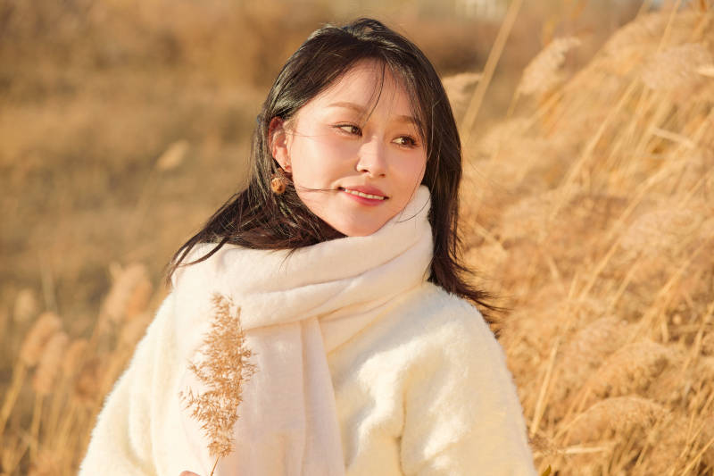 秋天午后在金灿灿的芦苇荡里的亚洲美女图片