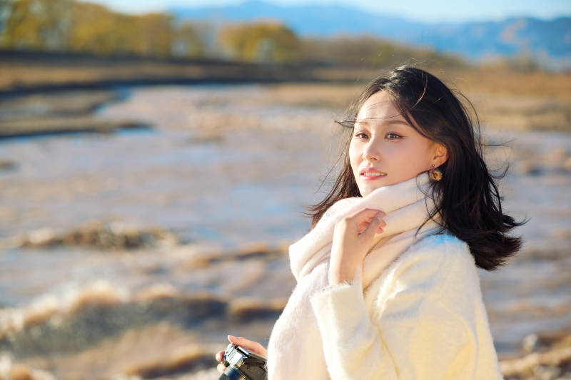 深秋户外手持相机的亚洲女性摄影师图片