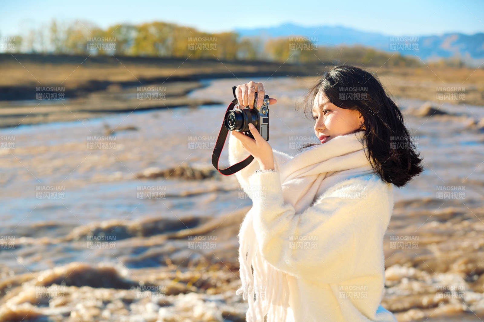 深秋户外手持相机的亚洲女性摄影师图片