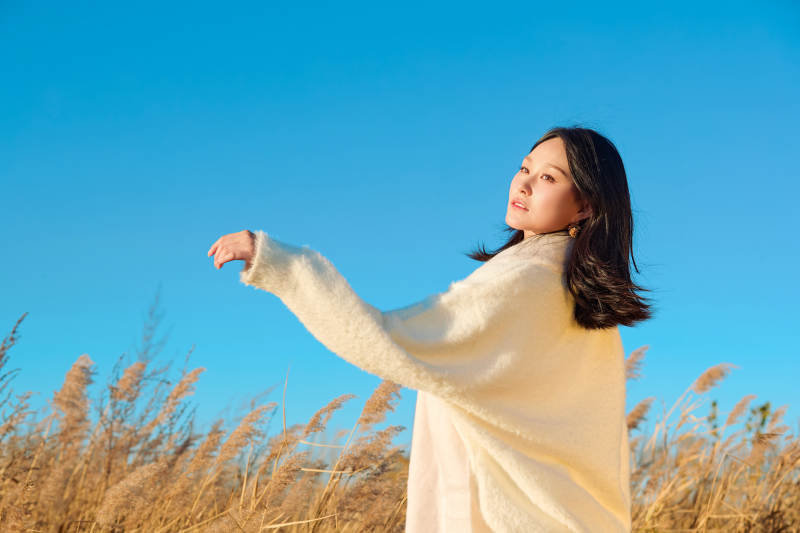 秋天晴朗的午后在芦苇荡里起舞的美女图片