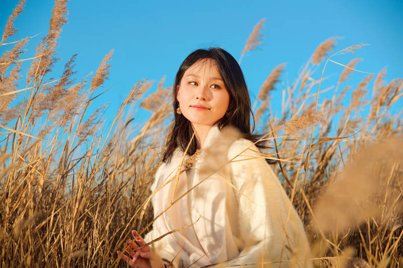 秋天晴朗的午后在芦苇荡里起舞的美女图片