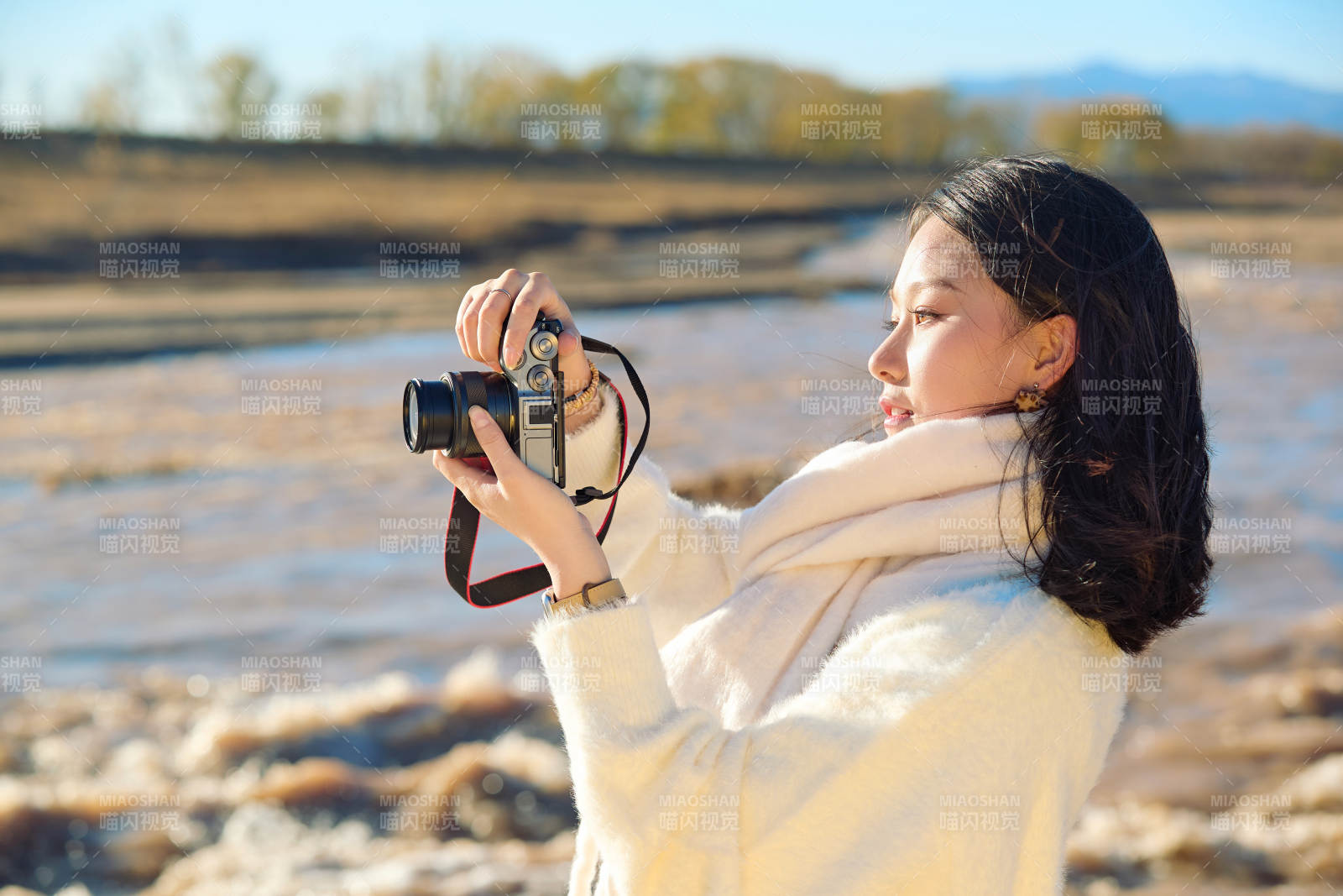 深秋户外手持相机的亚洲女性摄影师图片