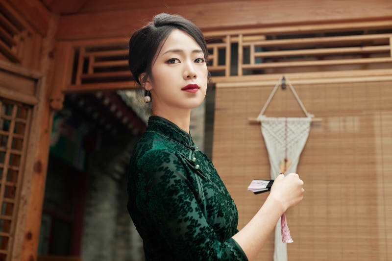 在中式庭院里身穿复古旗袍的亚洲女性图片