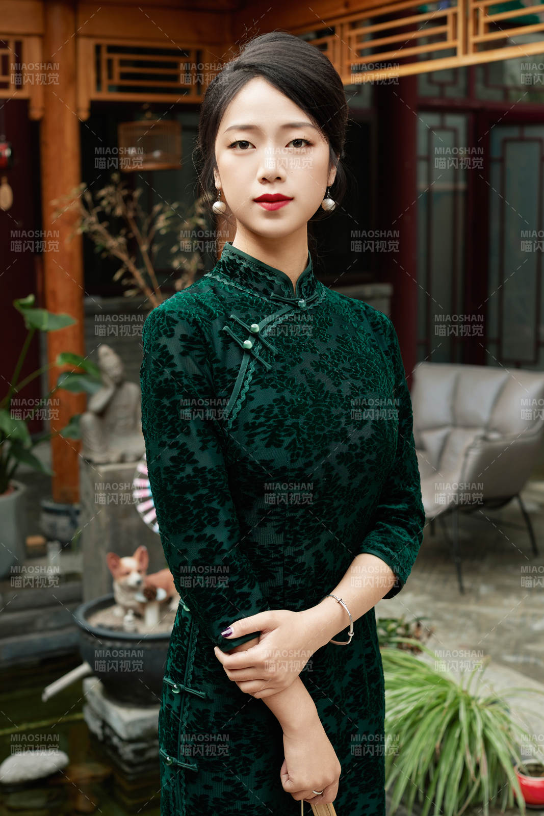 身穿旗袍在庭院散步的年轻美女图片