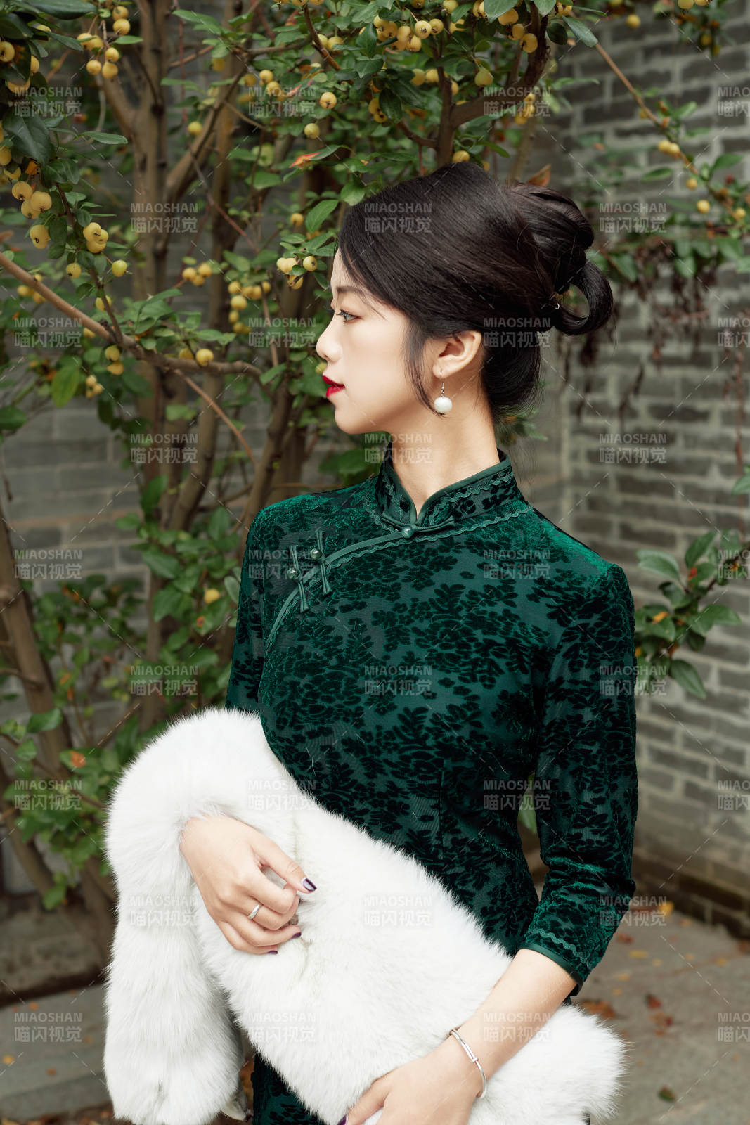 身穿旗袍在庭院散步的年轻美女图片