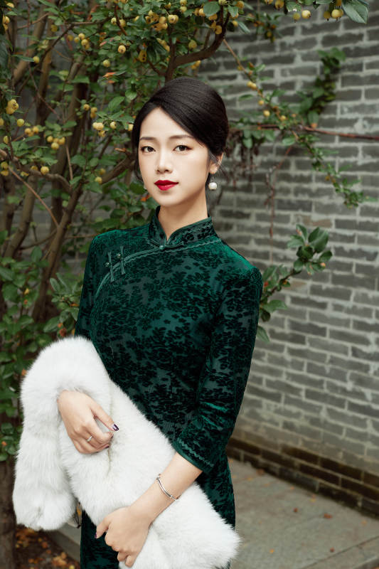 身穿旗袍在庭院散步的年轻美女图片