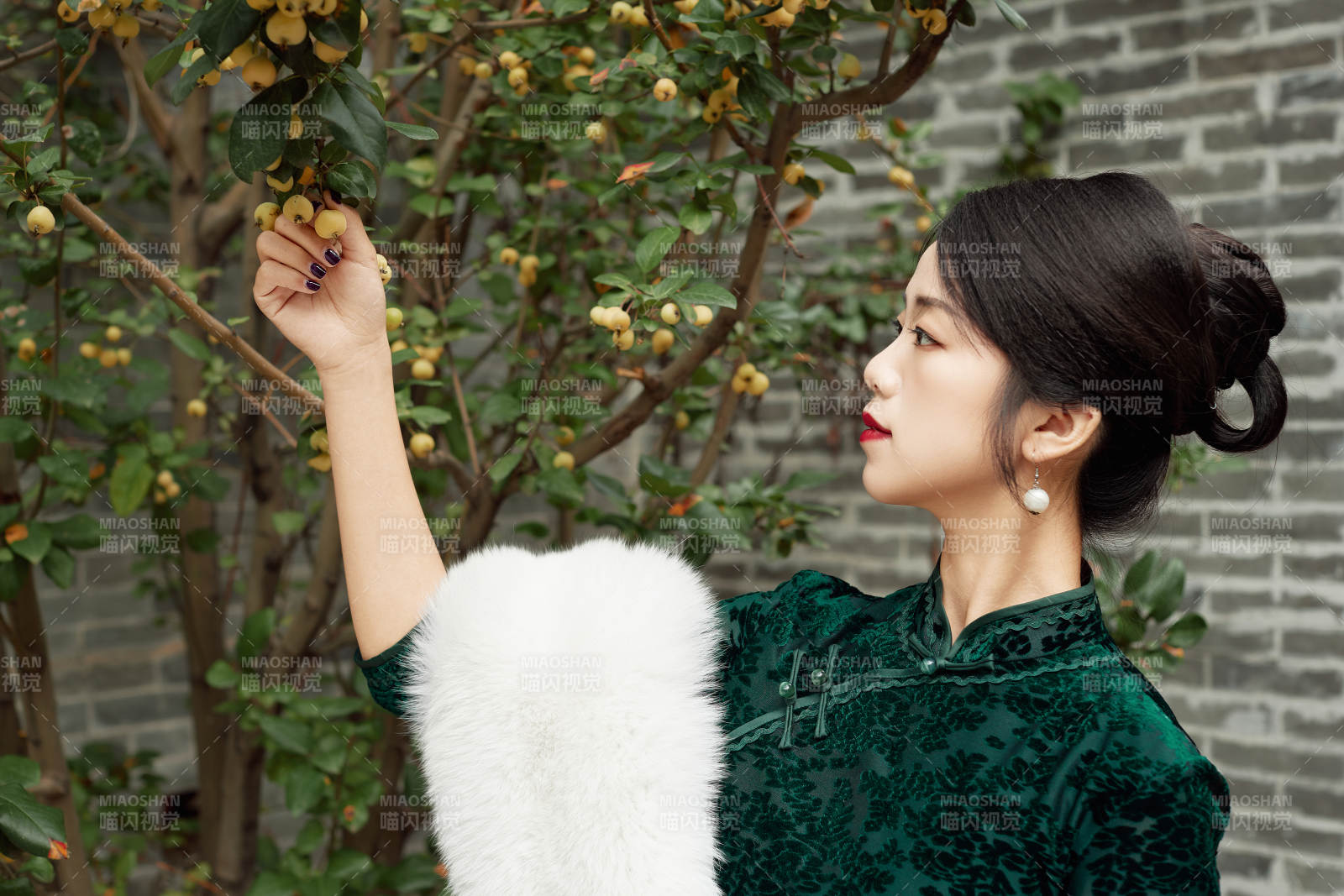 身穿旗袍在庭院散步的年轻美女图片