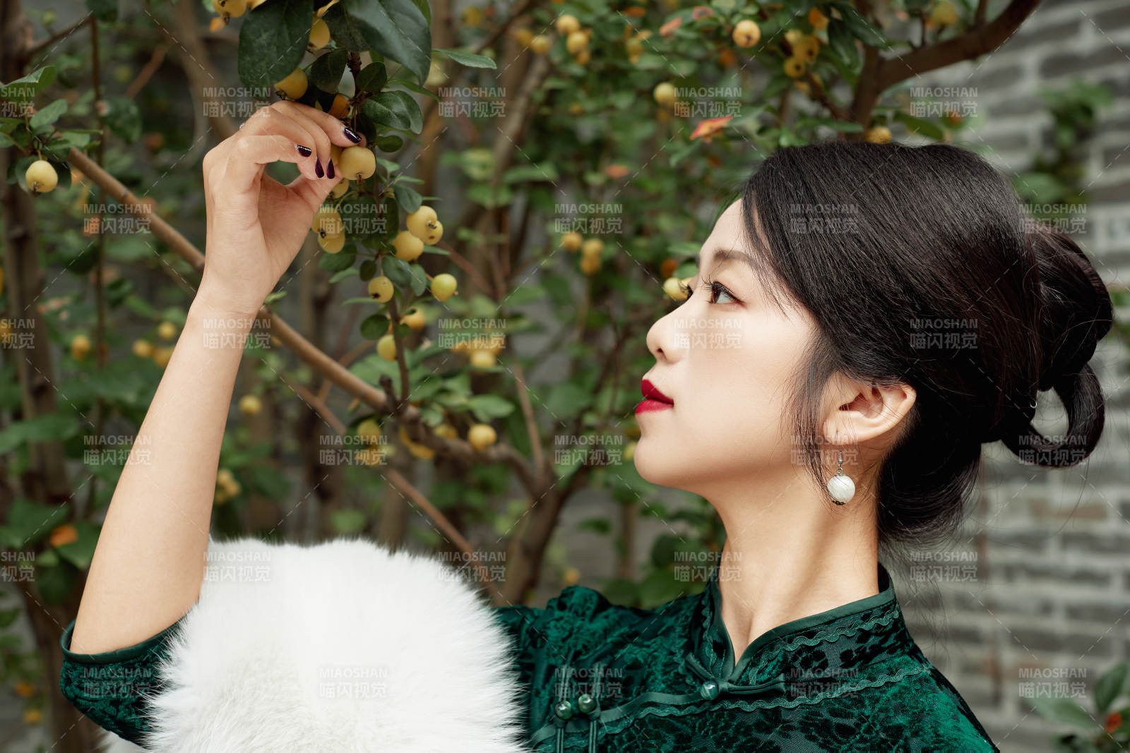 身穿旗袍在庭院散步的年轻美女图片