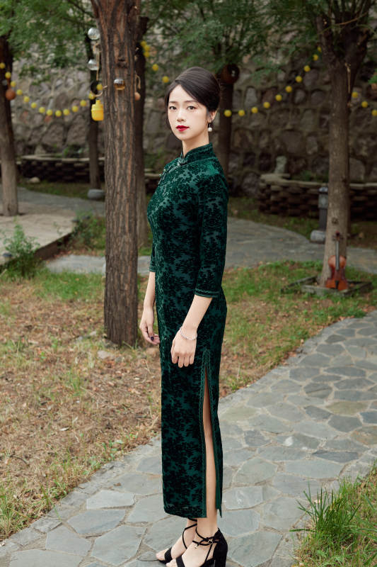 身穿旗袍在庭院散步的年轻美女图片