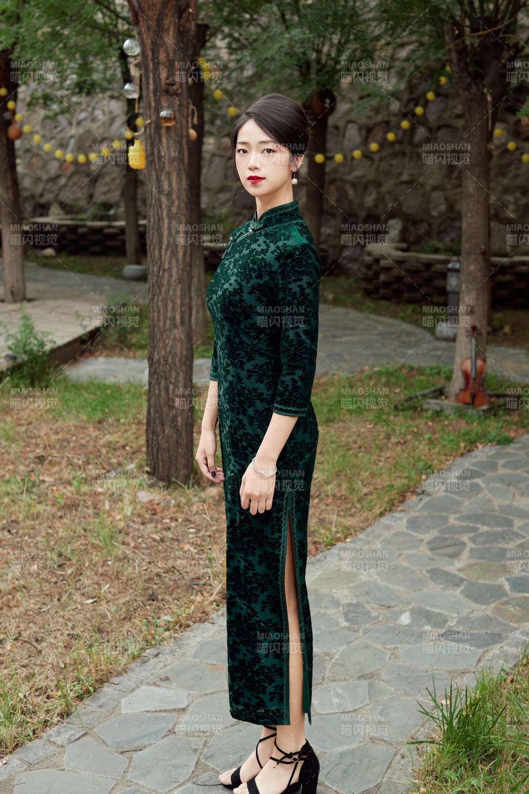 身穿旗袍在庭院散步的年轻美女图片