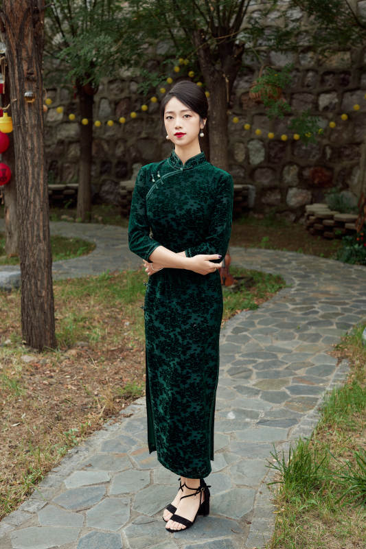 身穿旗袍在庭院散步的年轻美女图片