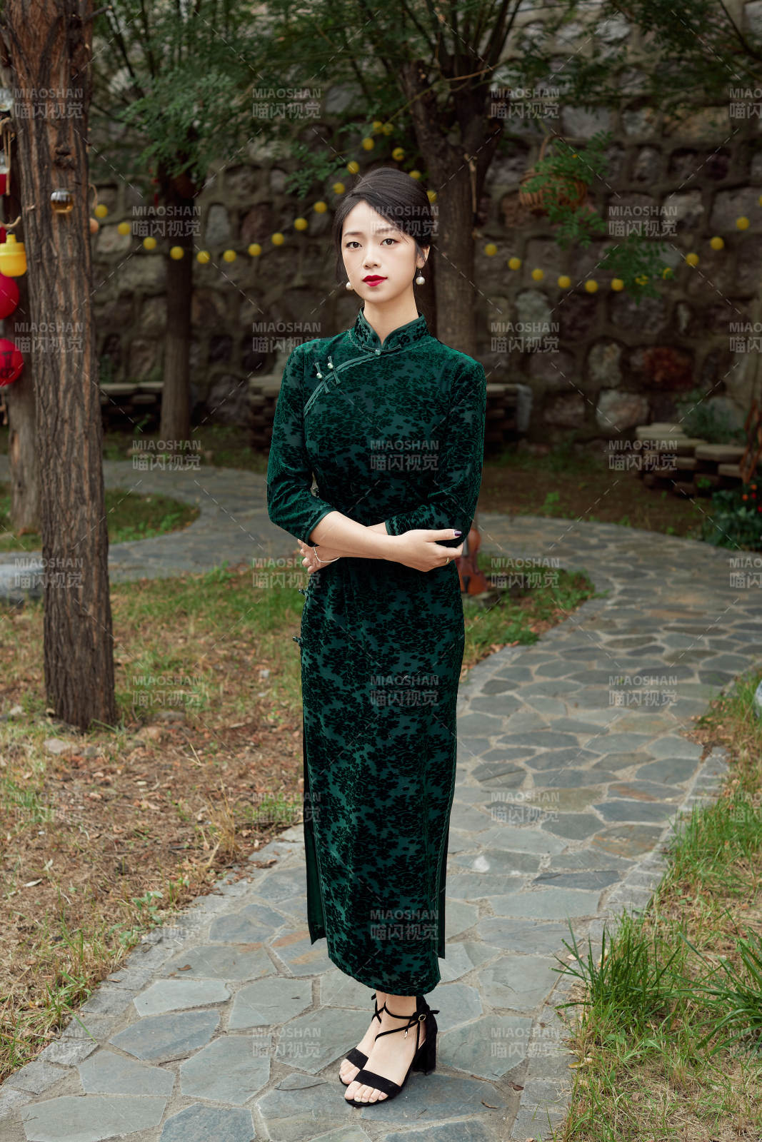 身穿旗袍在庭院散步的年轻美女图片