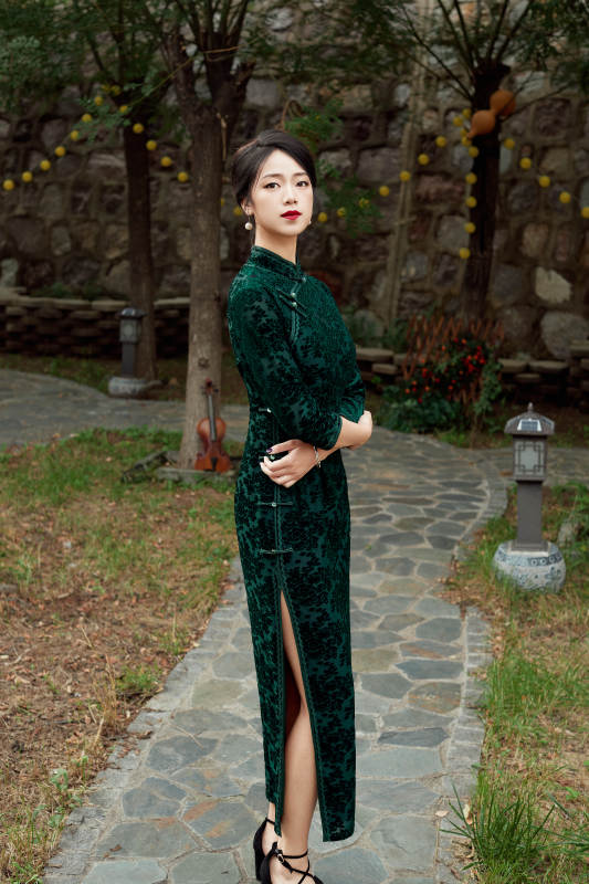 身穿旗袍在庭院散步的年轻美女图片