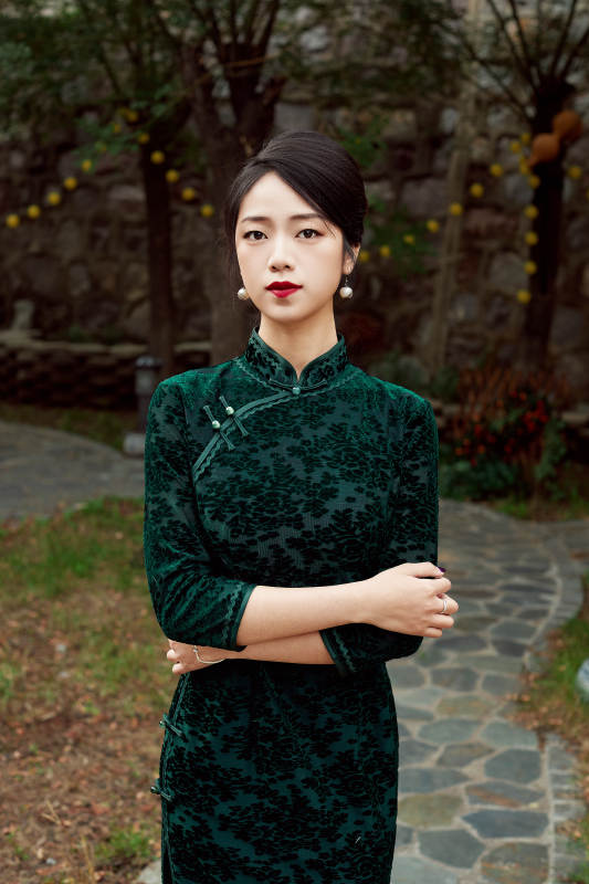 身穿旗袍在庭院散步的年轻美女图片