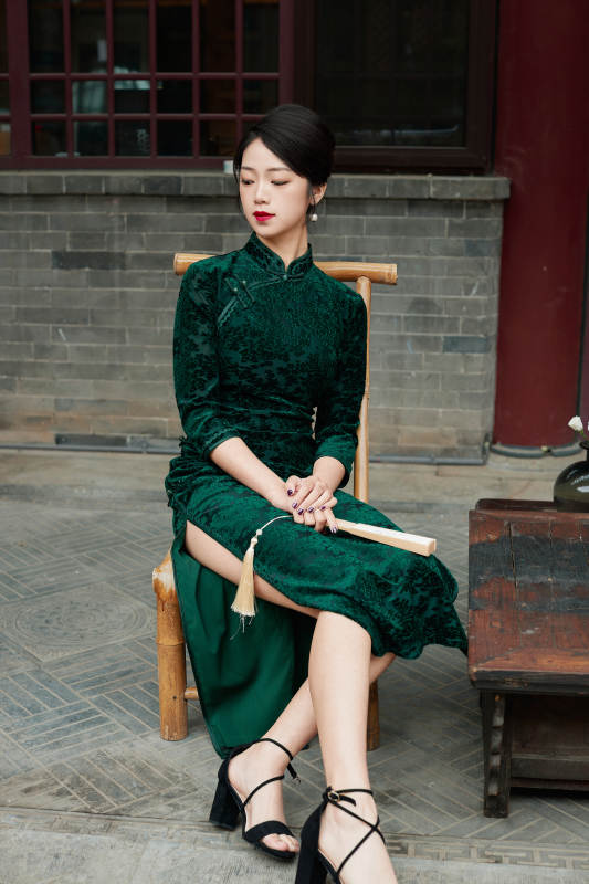 坐在中式庭院里身穿复古旗袍的亚洲女性图片