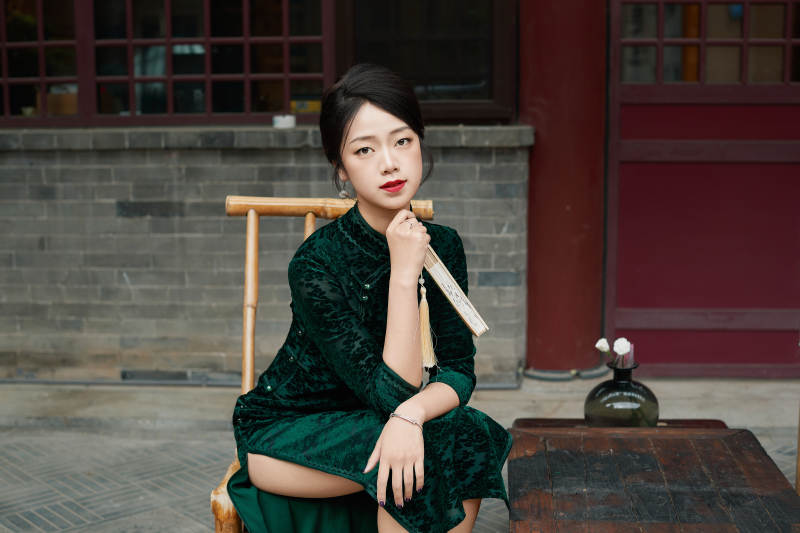 坐在中式庭院里身穿复古旗袍的亚洲女性图片