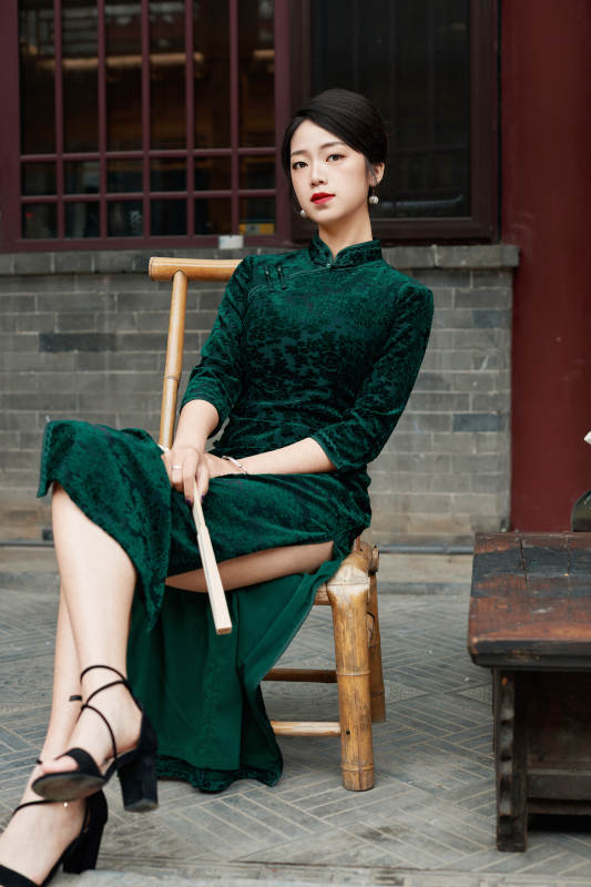 坐在中式庭院里身穿复古旗袍的亚洲女性图片