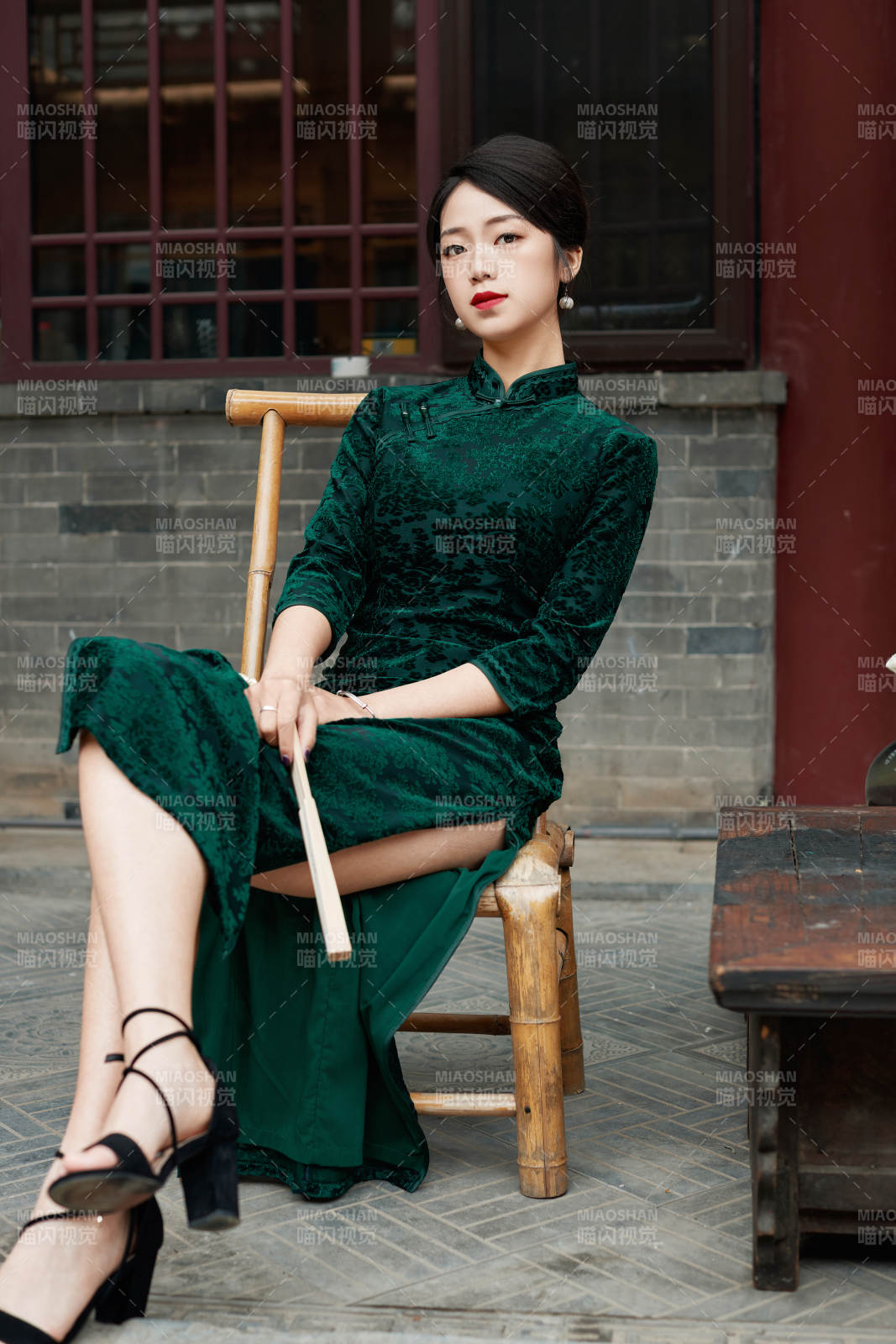 坐在中式庭院里身穿复古旗袍的亚洲女性图片