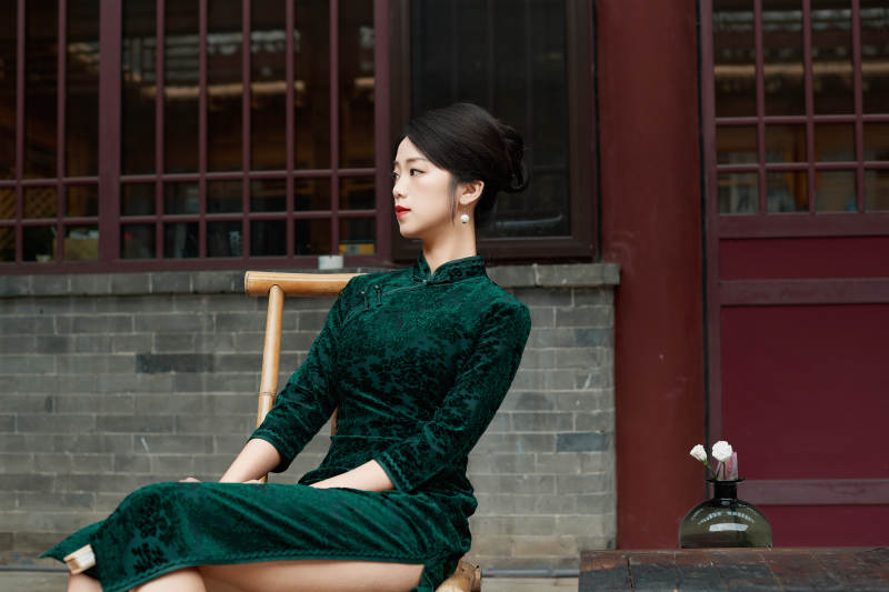 坐在中式庭院里身穿复古旗袍的亚洲女性图片