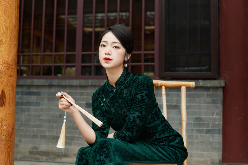 坐在中式庭院里身穿复古旗袍的亚洲女性图片