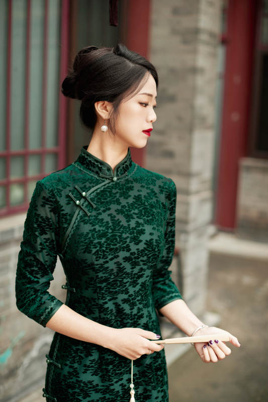 在中式庭院里身穿复古旗袍的亚洲女性图片