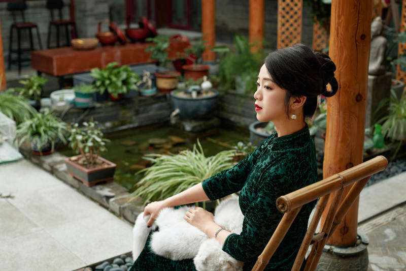 在中式庭院里身穿复古旗袍的亚洲女性图片