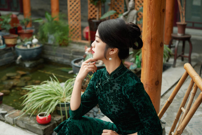 在中式庭院里身穿复古旗袍的亚洲女性图片