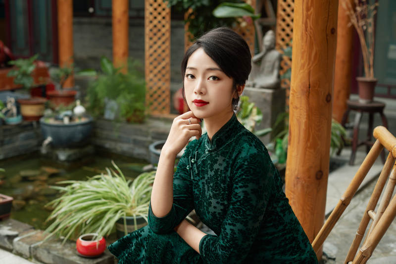 在中式庭院里身穿复古旗袍的亚洲女性图片