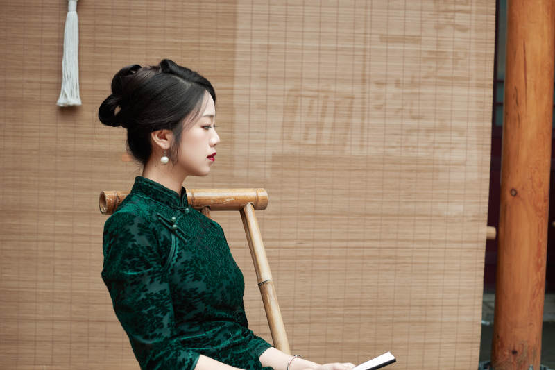 在中式庭院里身穿复古旗袍的亚洲女性图片