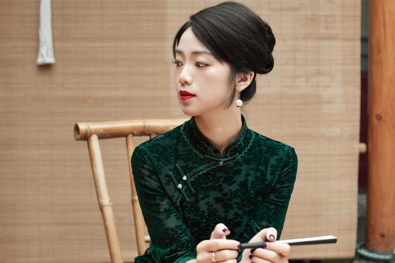 在中式庭院里身穿复古旗袍的亚洲女性图片