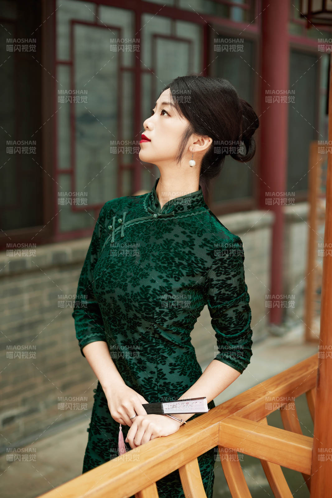 身穿旗袍在庭院散步的年轻美女图片