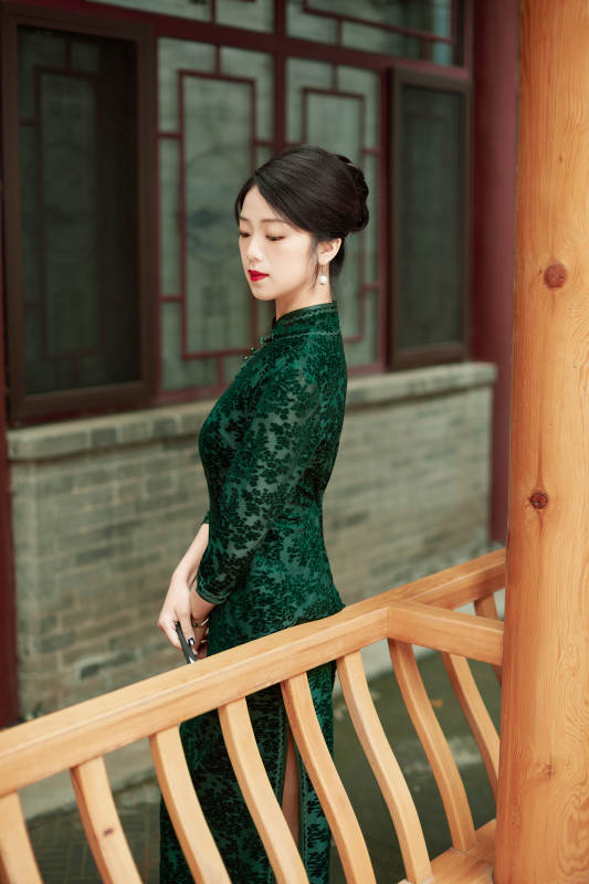 身穿旗袍在庭院散步的年轻美女图片