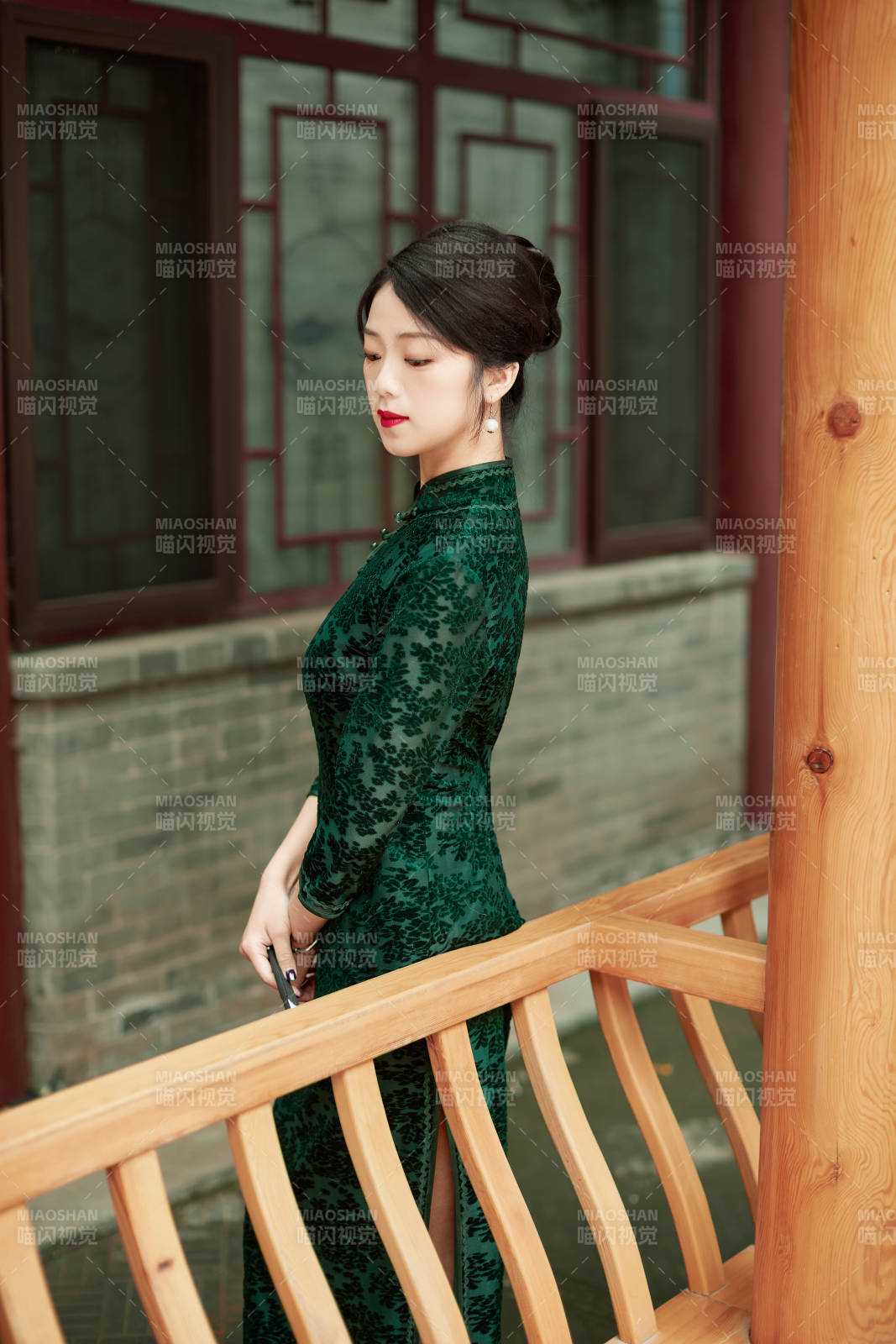 身穿旗袍在庭院散步的年轻美女图片