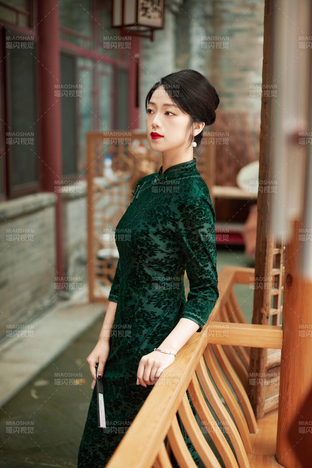 身穿旗袍在庭院散步的年轻美女图片