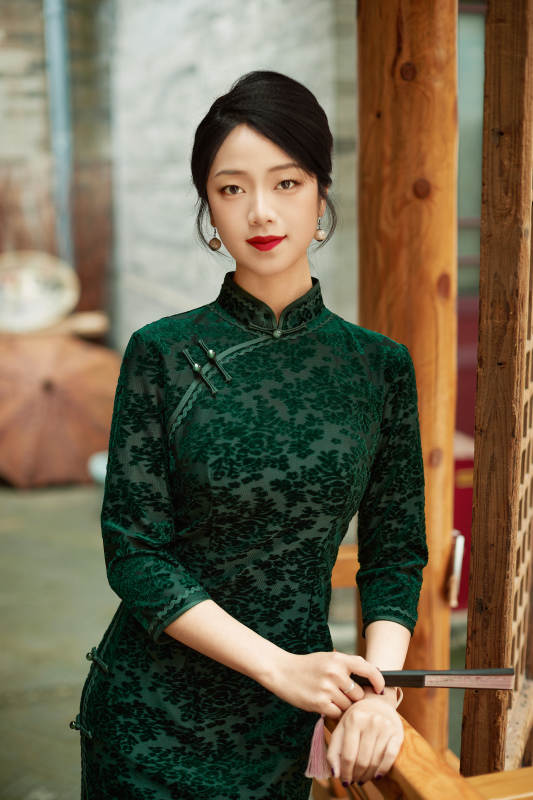 身穿旗袍在庭院散步的年轻美女图片