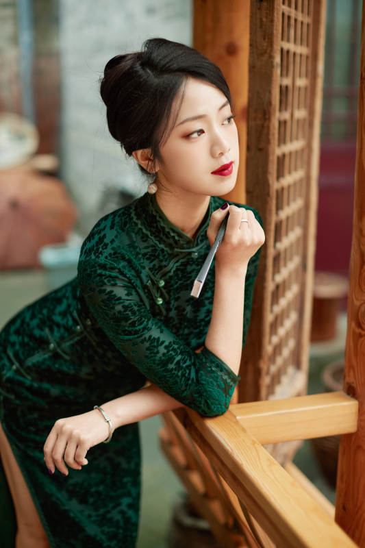 身穿旗袍在庭院散步的年轻美女图片